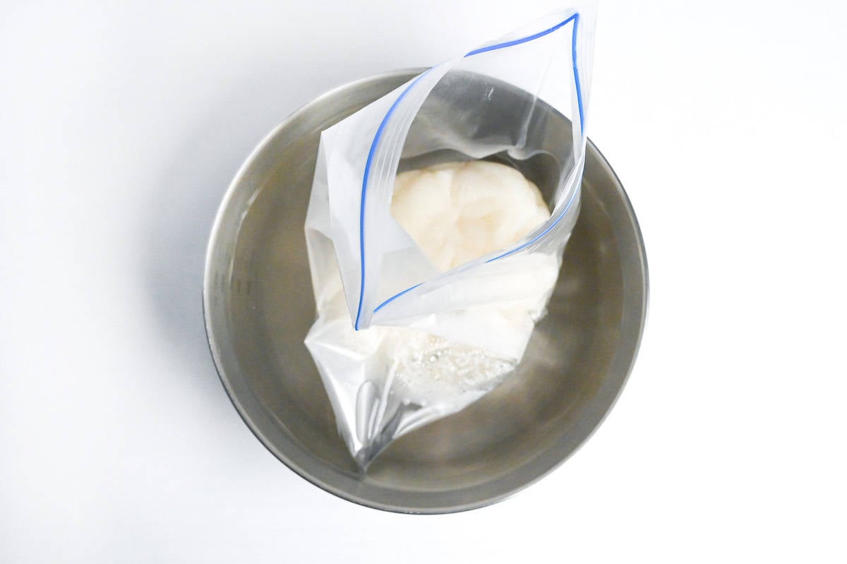 kashiwa mochi dough in a sealable freezer bag cooling in a bowl of cold water