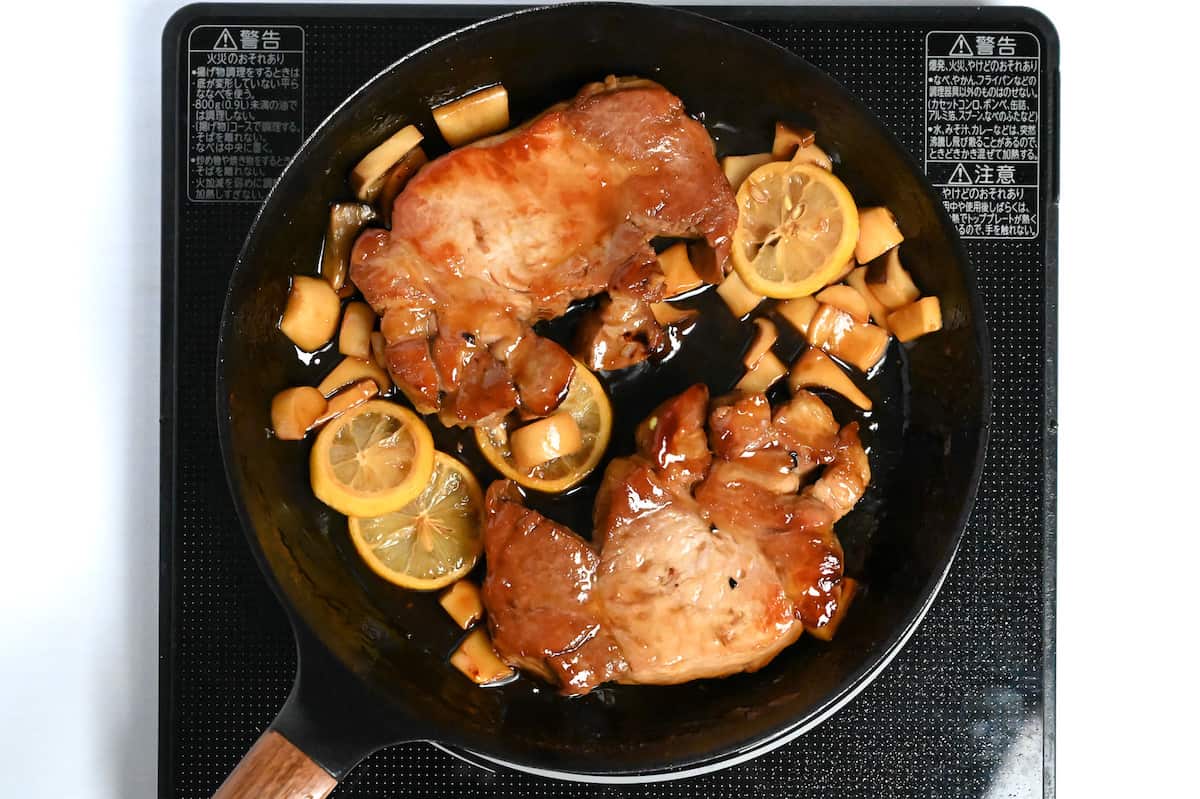 complete lemon teriyaki pork chops in a frying pan on the stove
