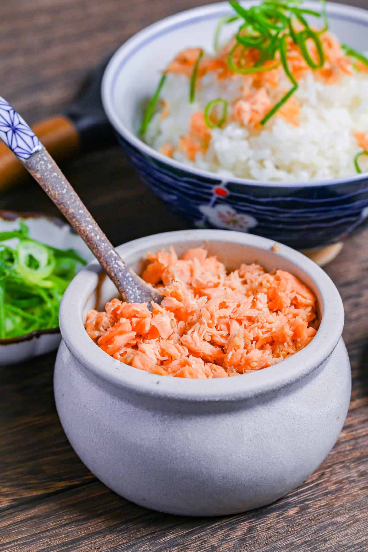 Homemade Japanese-style salmon flakes in a white ceramic pot with brown decorative spoon