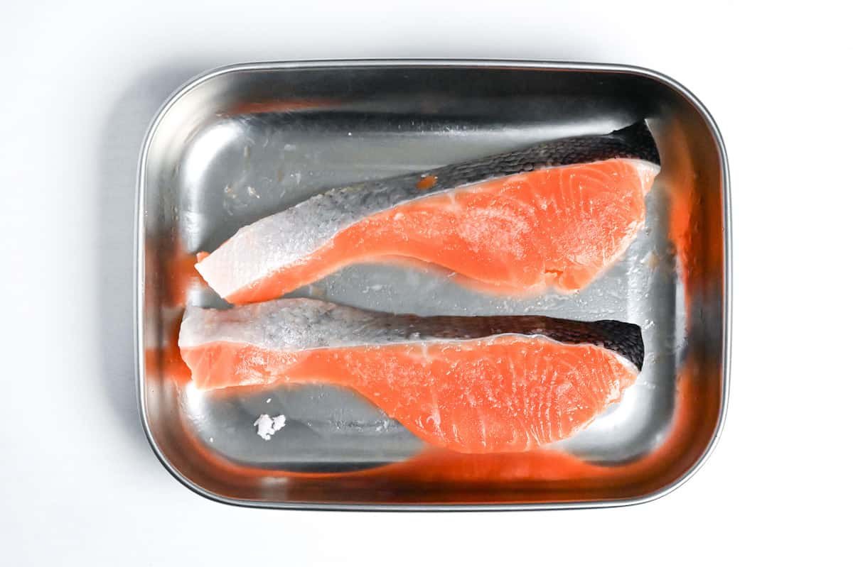 two salmon fillets in a steel container