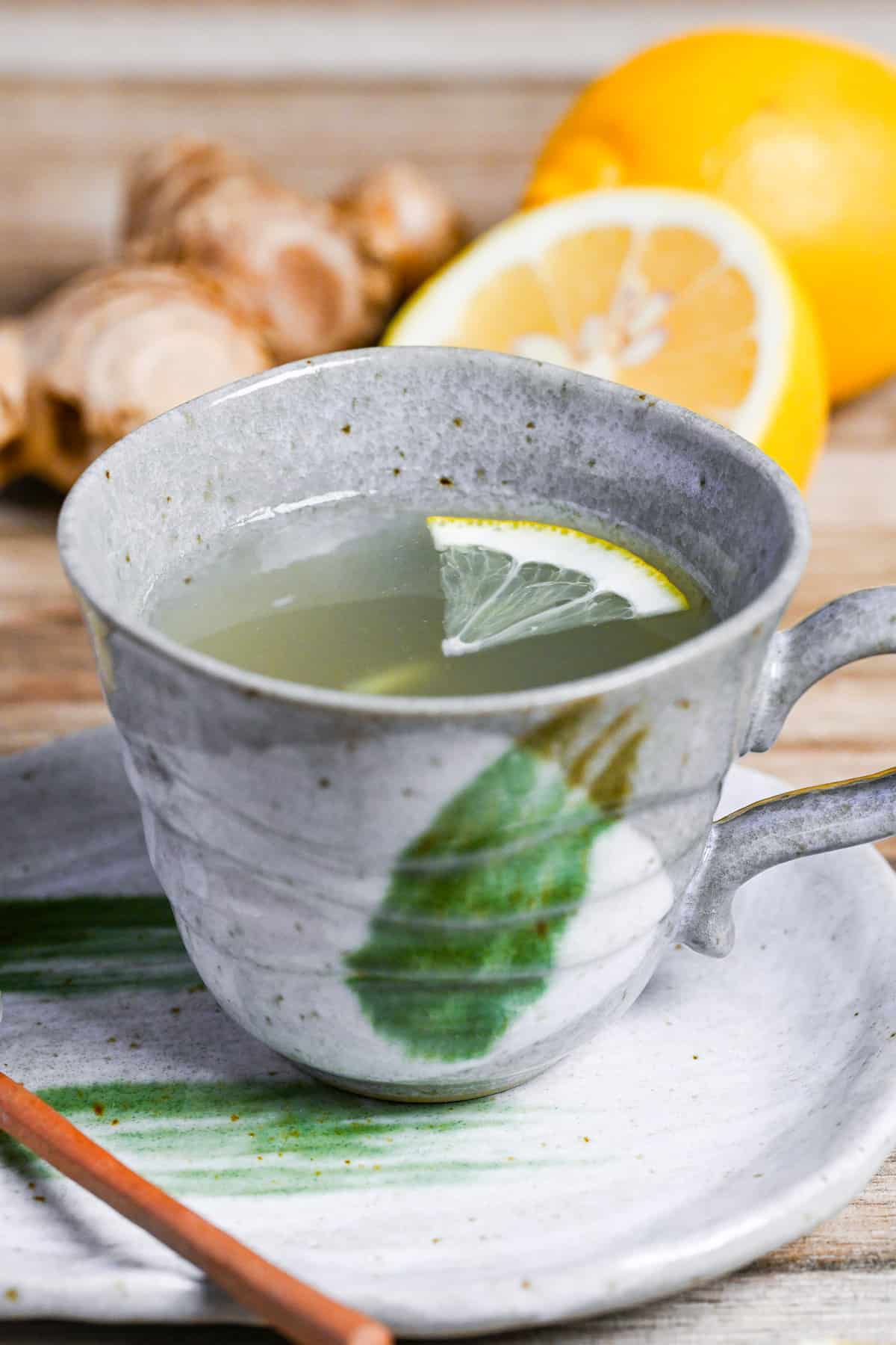 Japanese ginger tea (shogayu) in a gray cup with lemon and ginger pieces