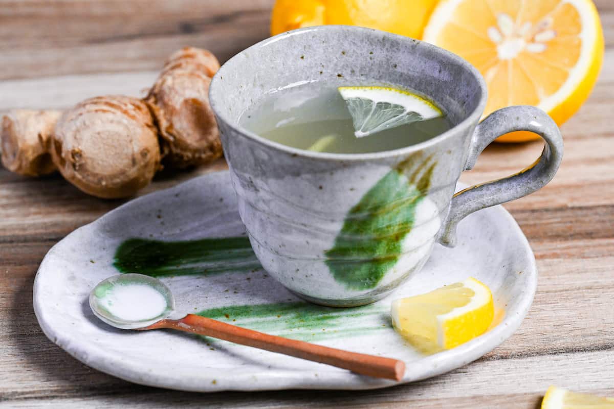 Japanese ginger tea (shogayu) in a gray cup with lemon and ginger pieces