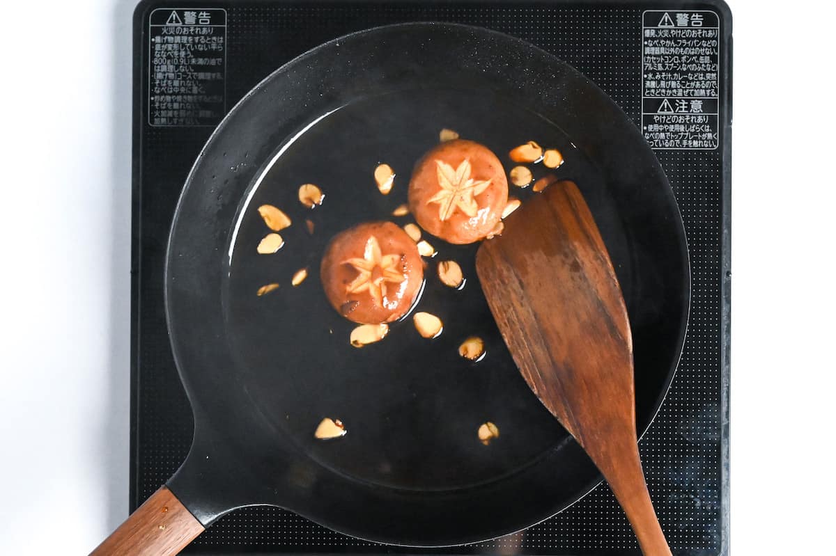shiitake mushrooms cooking in sukiyaki-style sauce in a frying pan