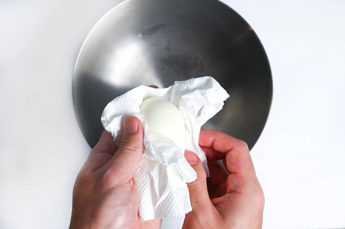 drying peeled egg with kitchen paper