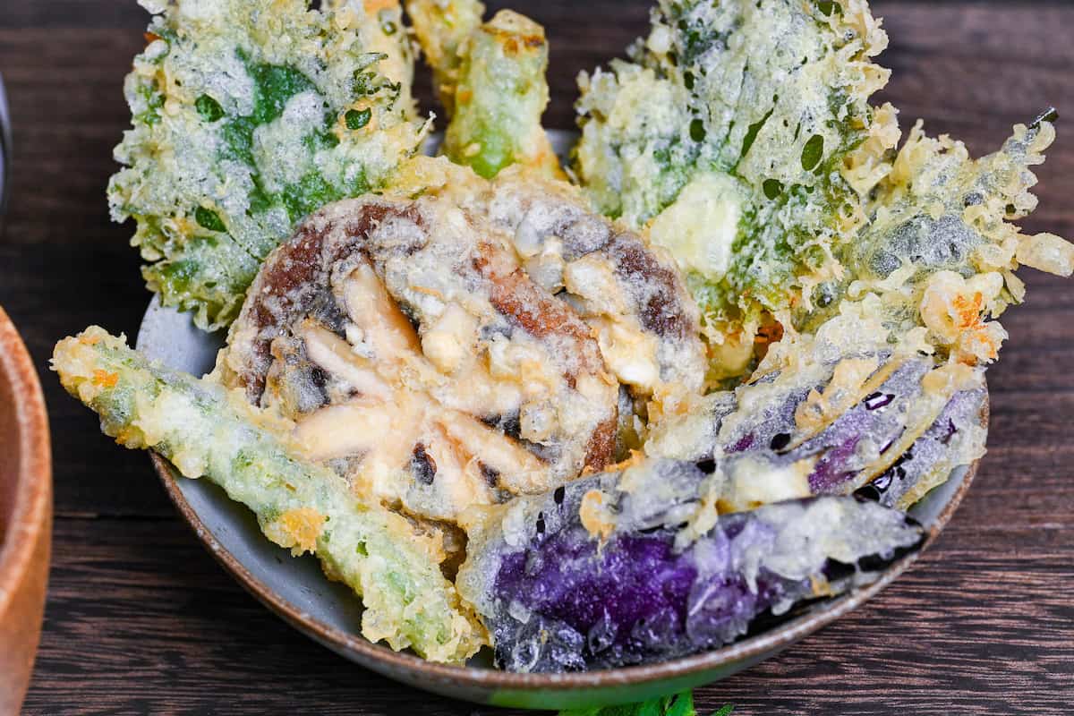 close up of vegetable tempura made with shiitake mushrooms, eggplants, shiso leaves and asparagus