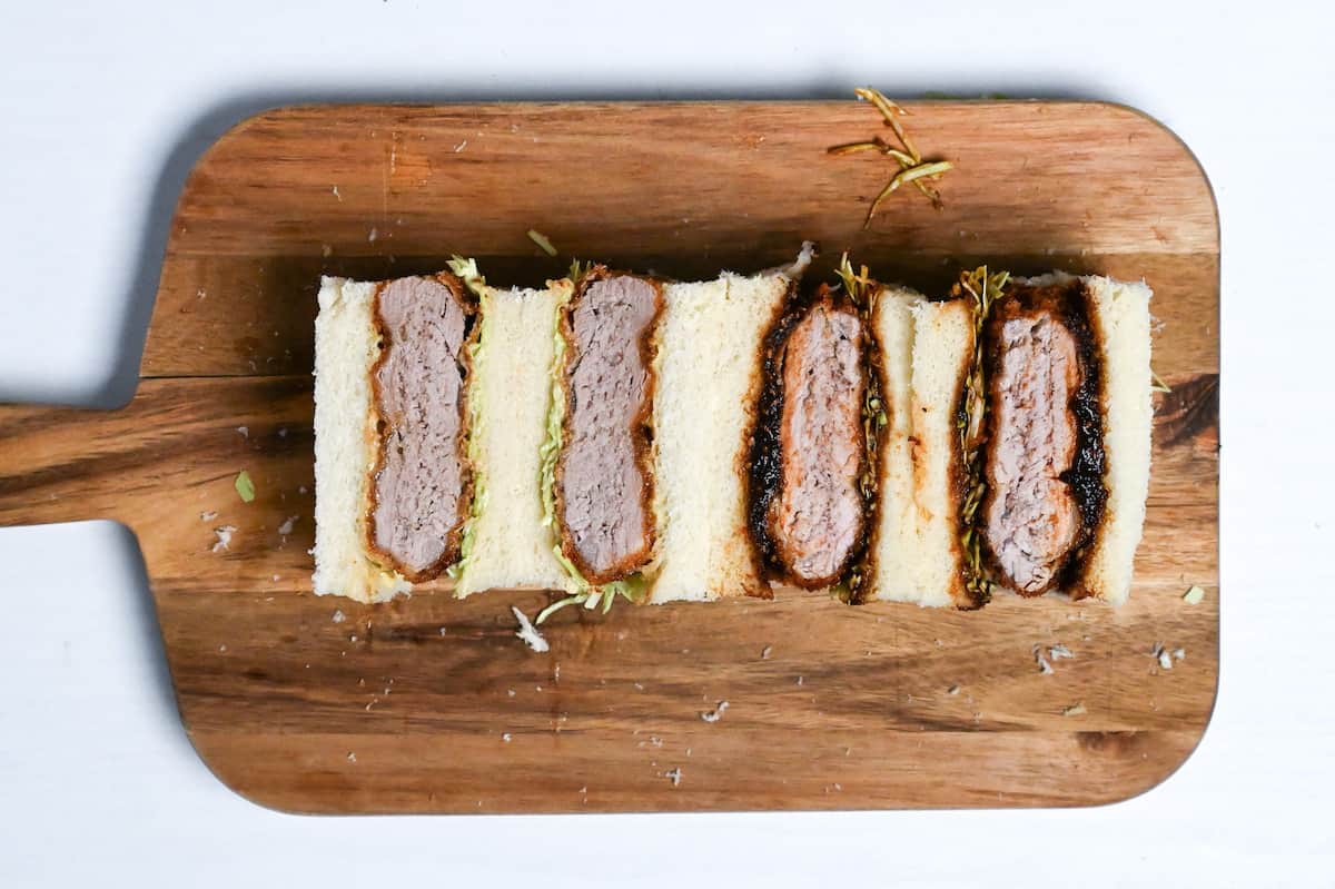 two kinds of katsu sando on a wooden chopping board