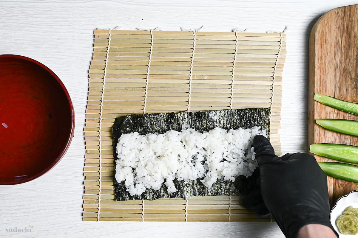 rice spread on nori with finger-width border along the top to make hosomaki