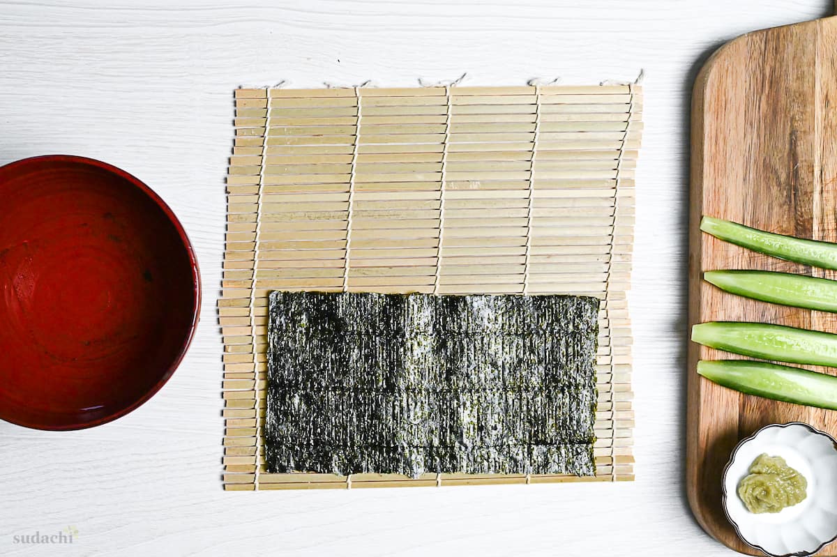 nori aligned with the bottom of a bamboo sushi rolling mat