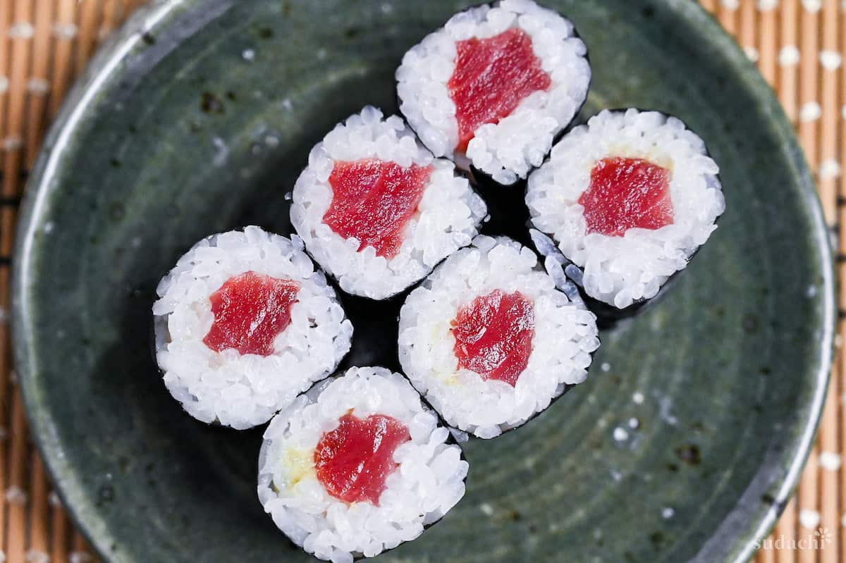 six tekkamaki tuna sushi rolls on a green plate