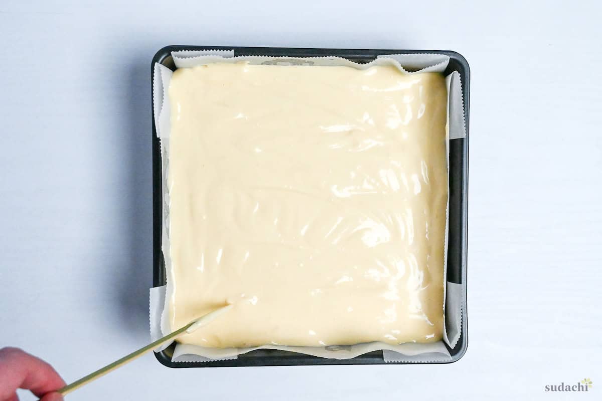castella cake batter in a lined square cake pan