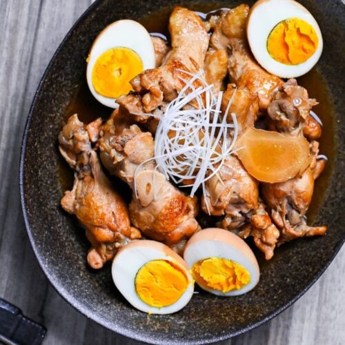 Tori no Sappari-ni made with chicken drumsticks and boiled eggs simmered in a vinegar based broth served in a black oval shaped bowl