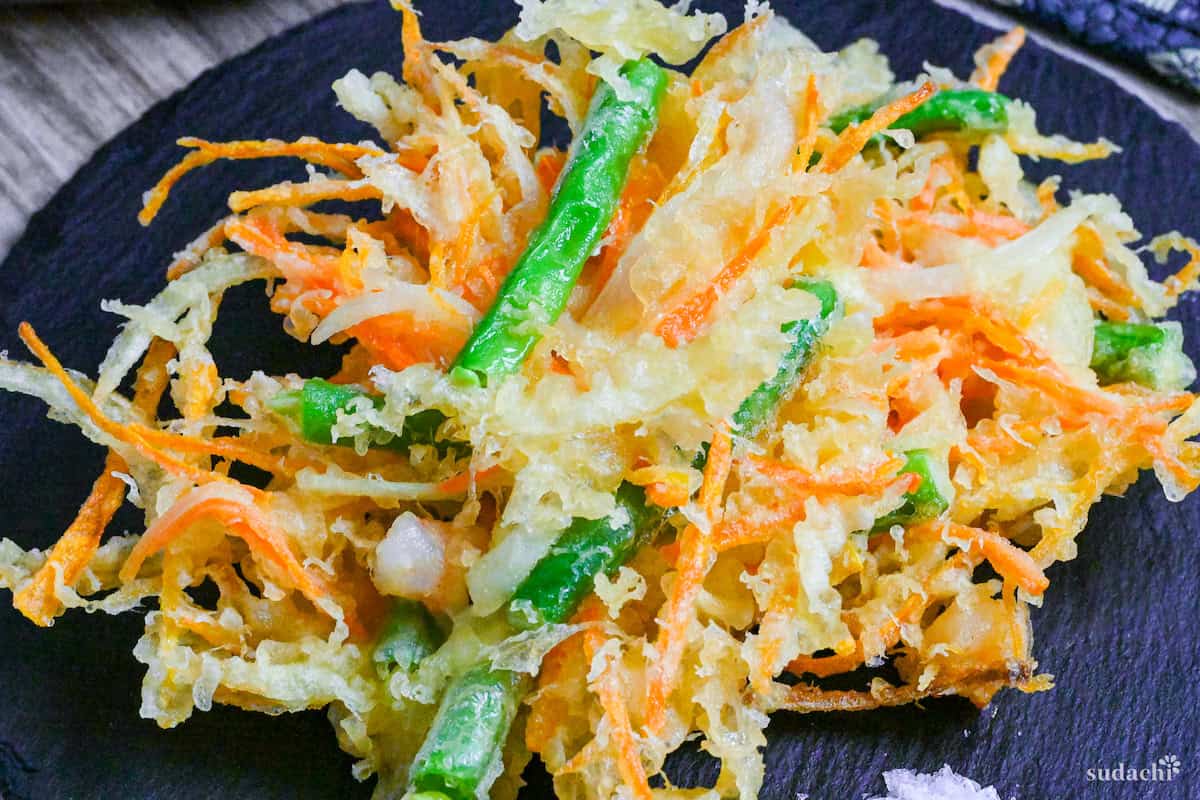 A close up of Kakiage (Japanese mixed vegetable tempura) on a slate plate