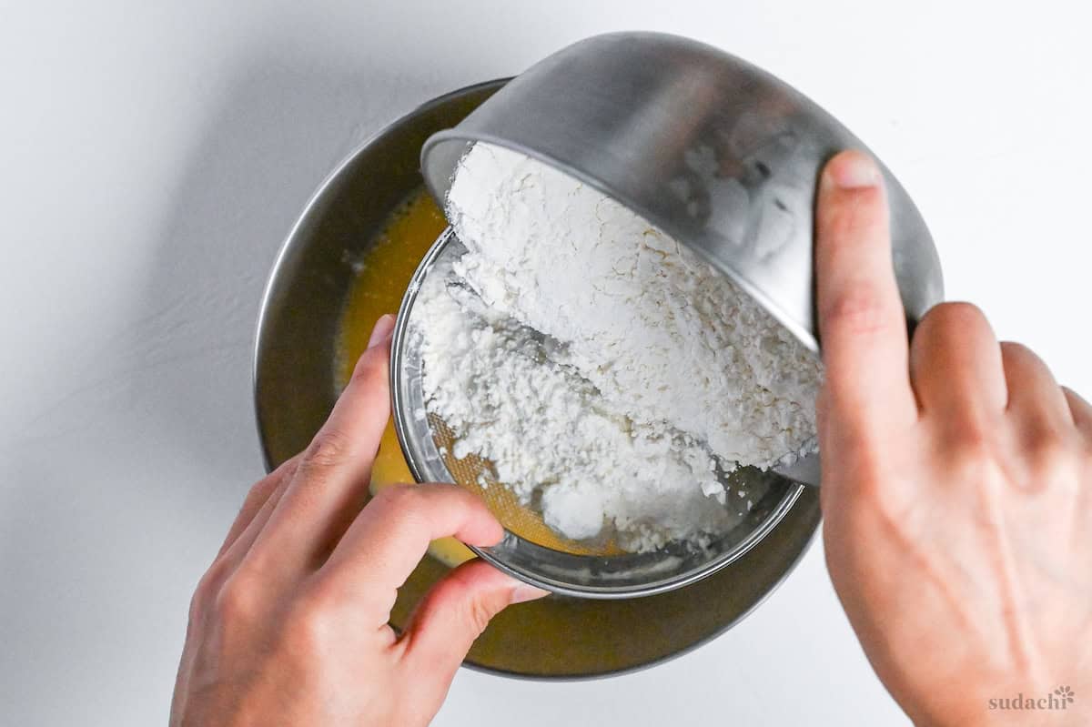 sifting flour into egg mixture to make tempura batter for kakiage