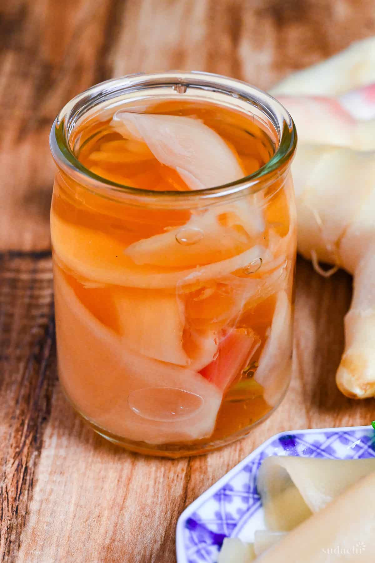 homemade pickled sushi ginger in a small glass jar on a wooden background