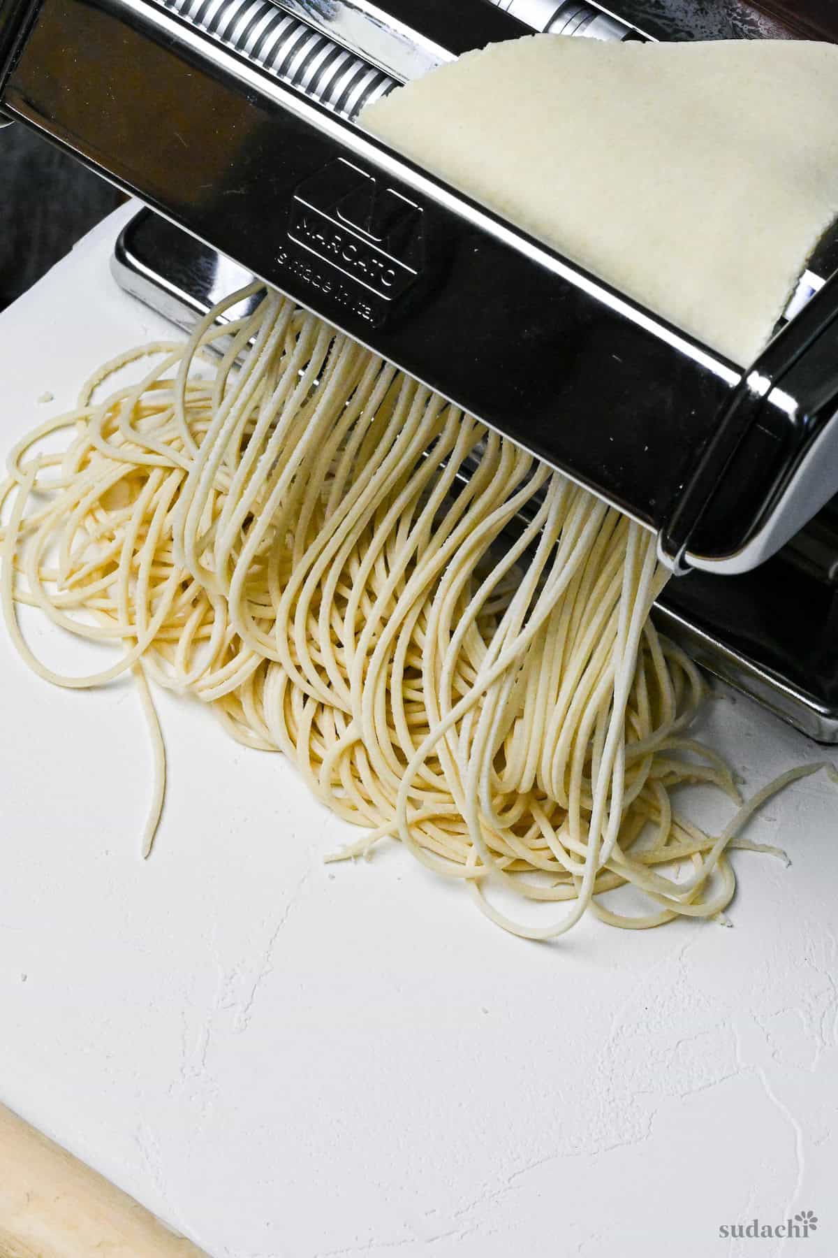 handmade ramen noodles rolling through pasta machine