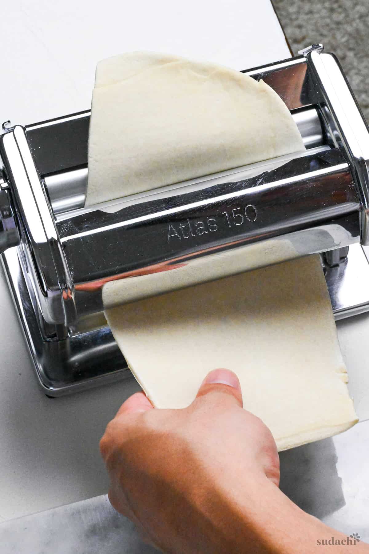 rolling dough for handmade ramen noodles through pasta machine