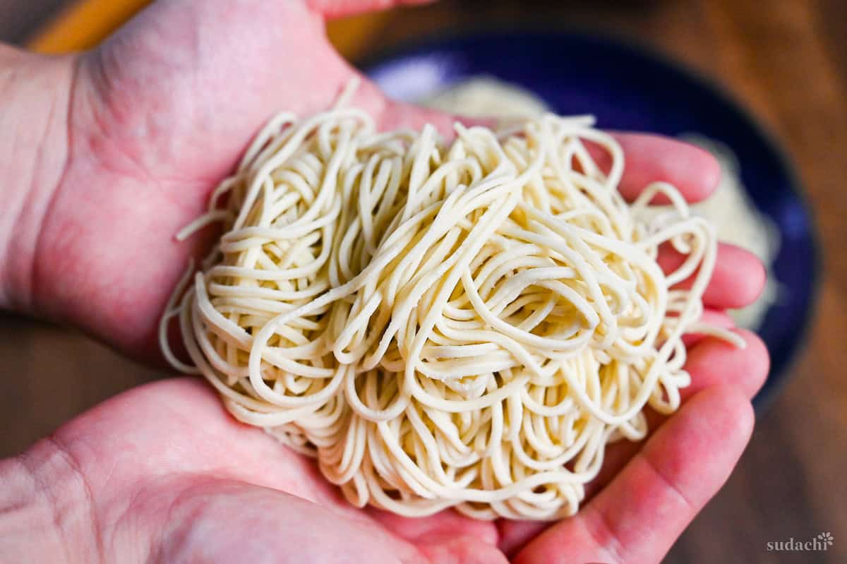 a bundle of homemade ramen noodles held in two hands