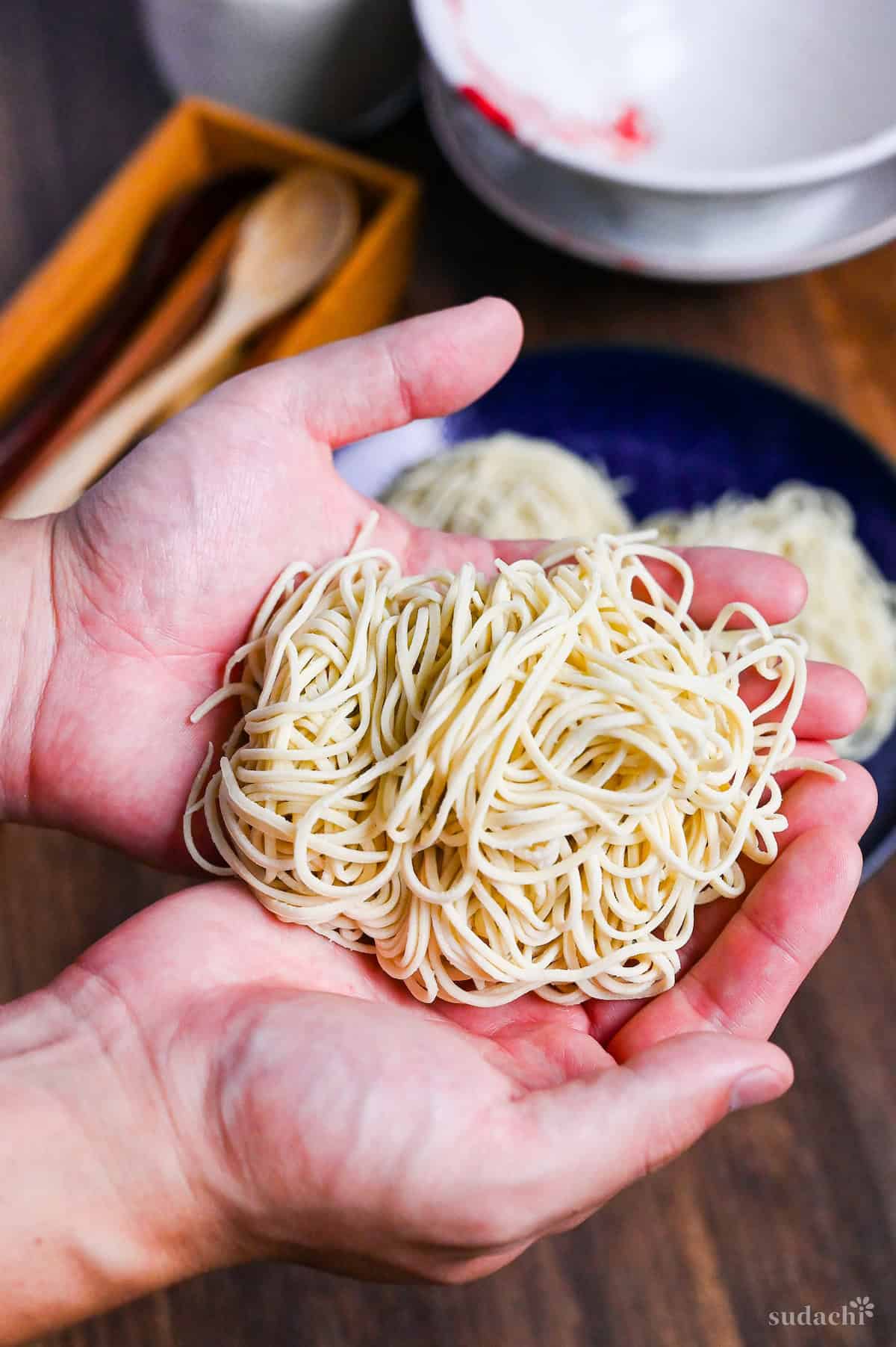 a bundle of homemade ramen noodles held in two hands