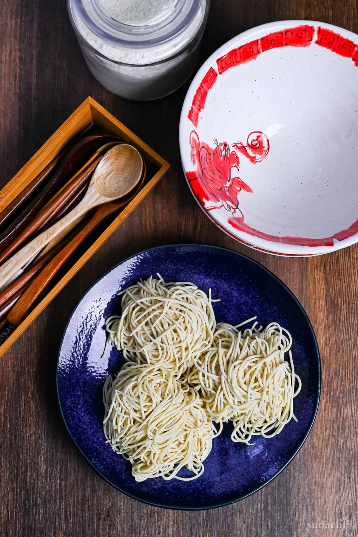 three bundles of homemade ramen noodles on a blue plate on a wooden background