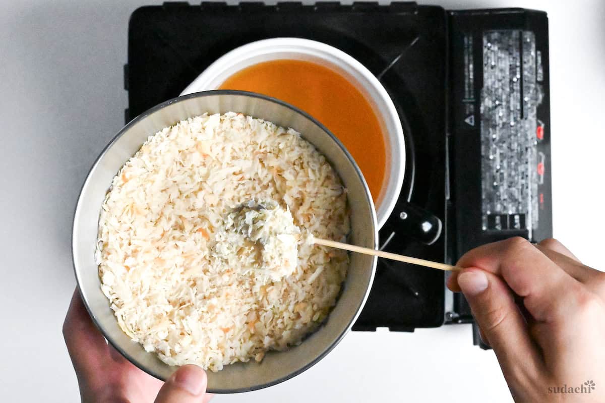 coating batter covered shrimp on a bamboo skewer in panko breadcrumbs ready to make kushi age