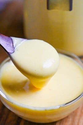 a wooden spoon scooping Japanese mayonnaise out of a small glass bowl thumbnail