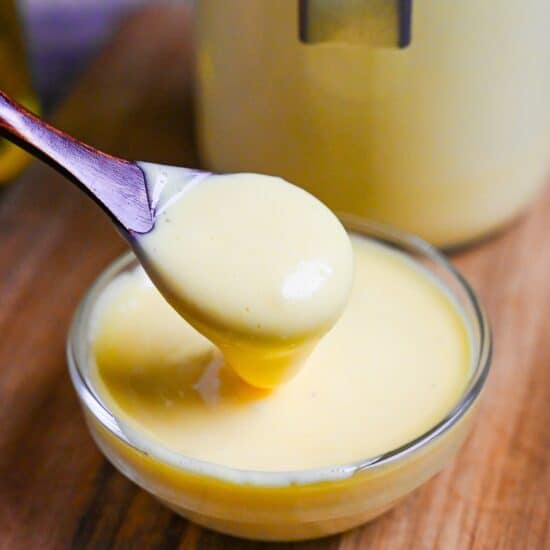 a wooden spoon scooping Japanese mayonnaise out of a small glass bowl thumbnail