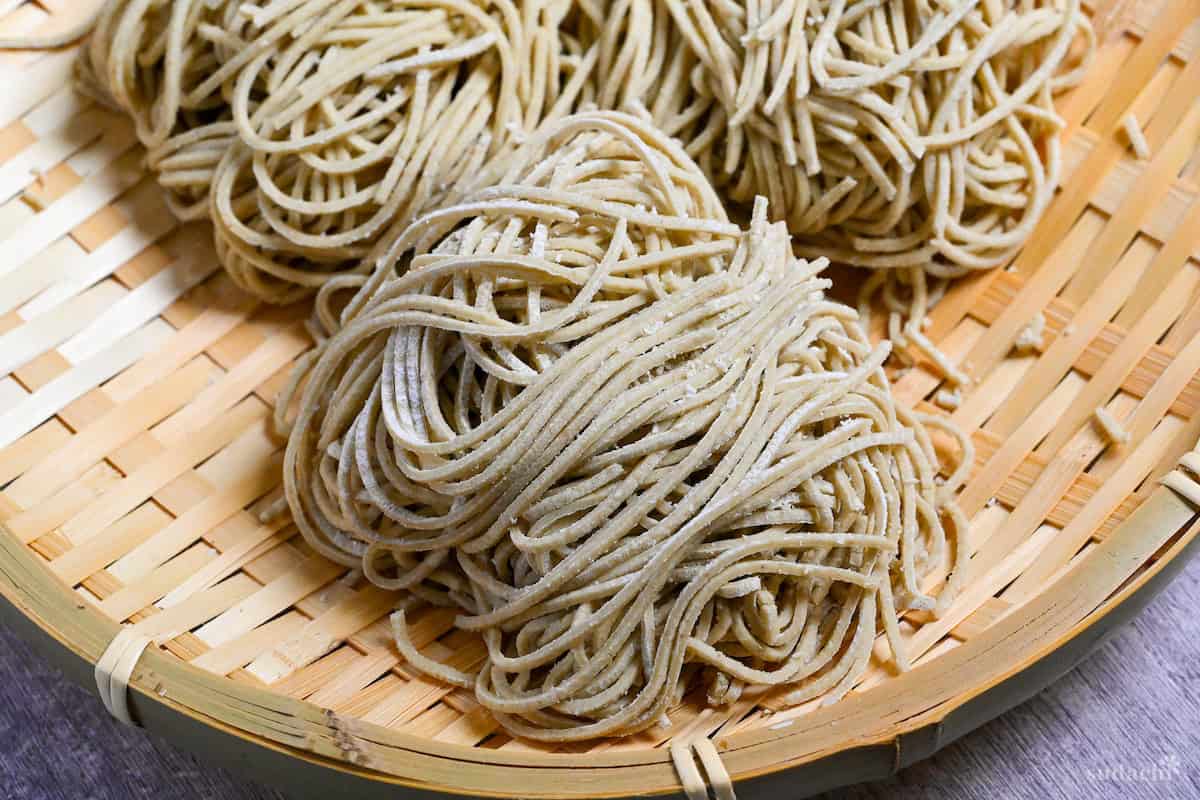 three bundles of homemade soba noodles on a bamboo tray