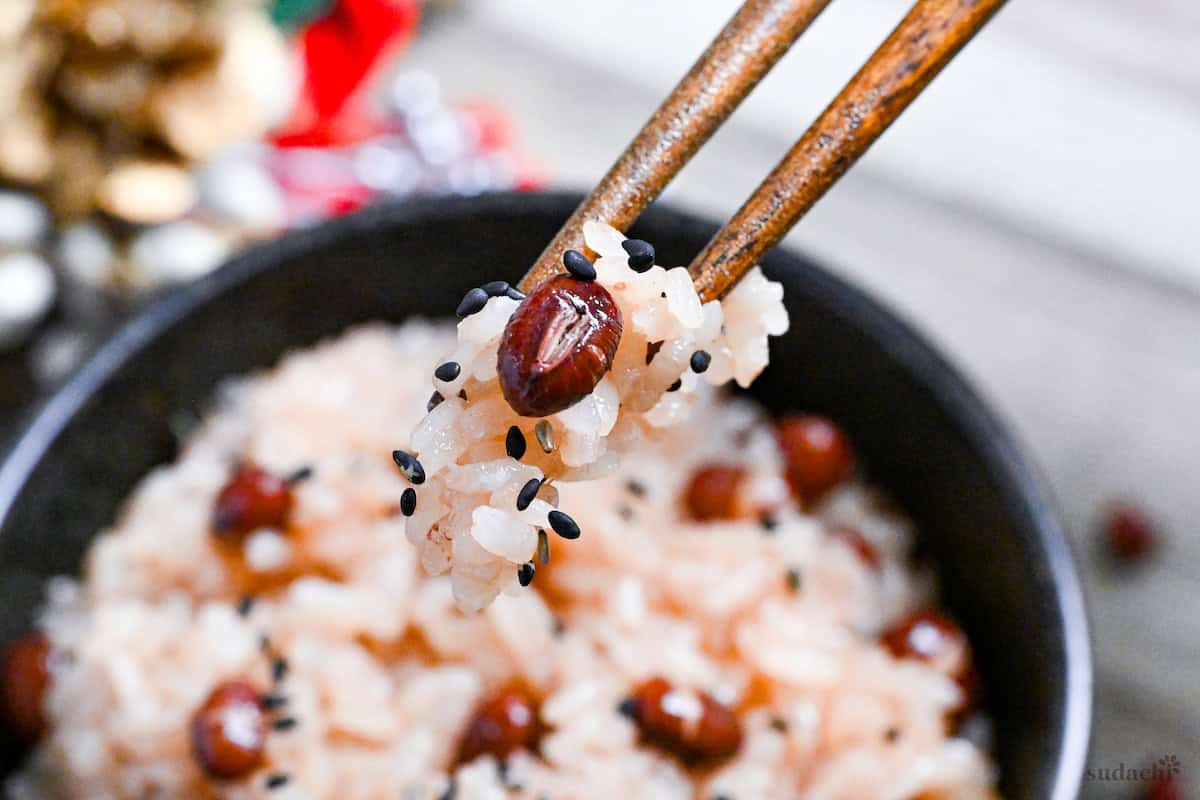 sekihan red bean rice held with wooden chopsticks