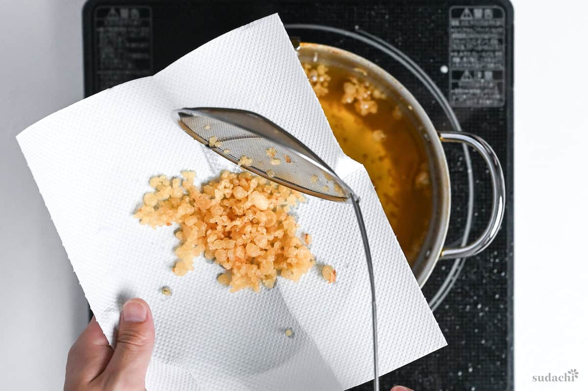 draining crispy tempura flakes on kitchen paper to absorb oil