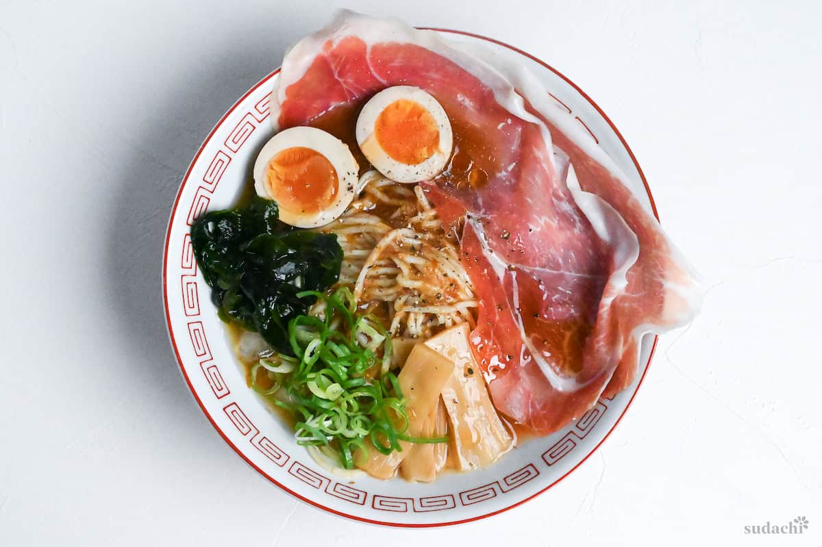 cold ramen noodles topped with cured ham, soft boiled eggs, wakame, chopped green onion and menma bamboo shoots