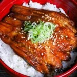 eggplant kabayaki over rice in a red bowl