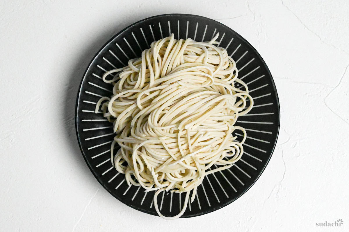 raw homemade ramen noodles test on a black plate with white stripes