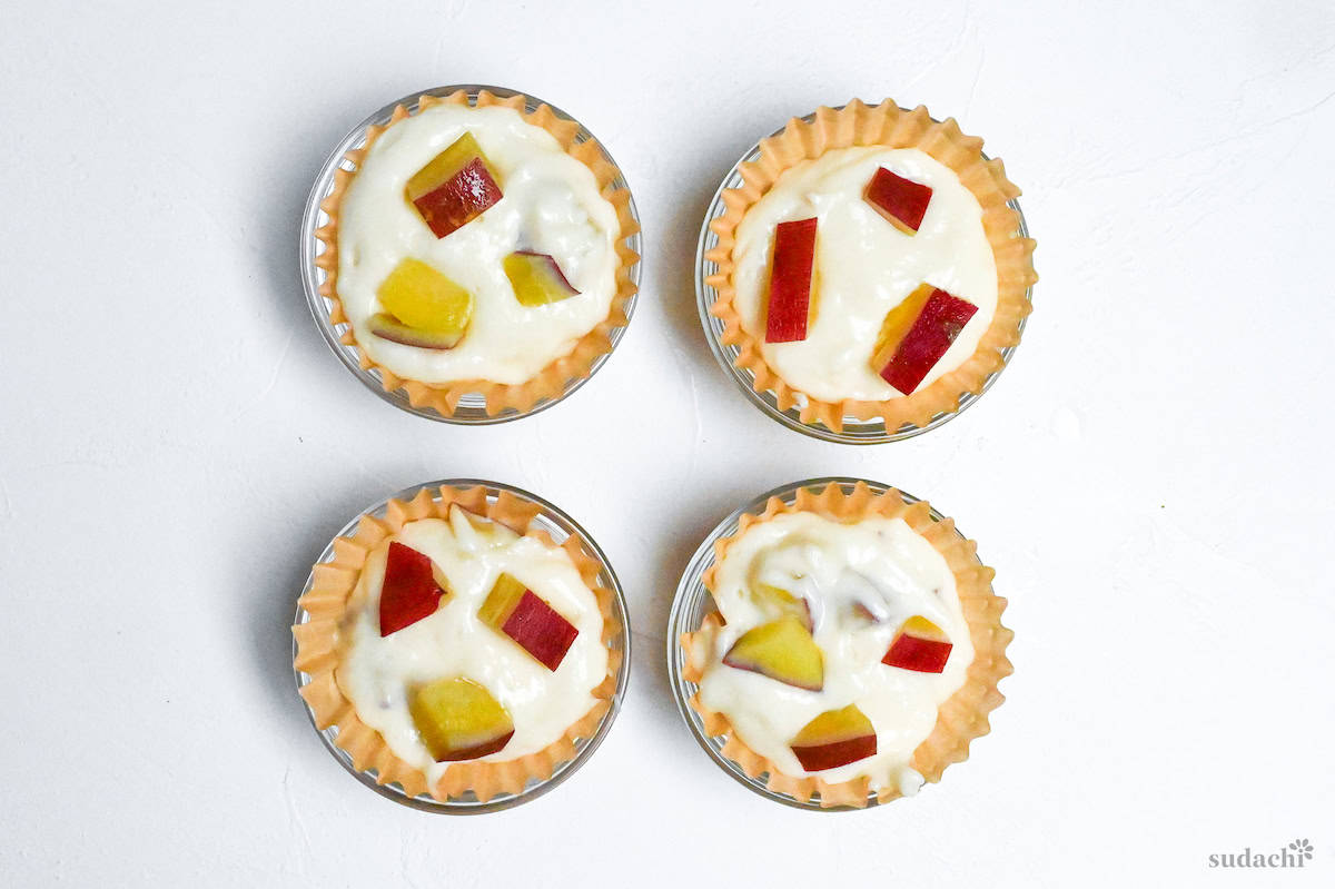 4 sweet potato mushi pan in paper cupcake cases in glass ramekins on a white background