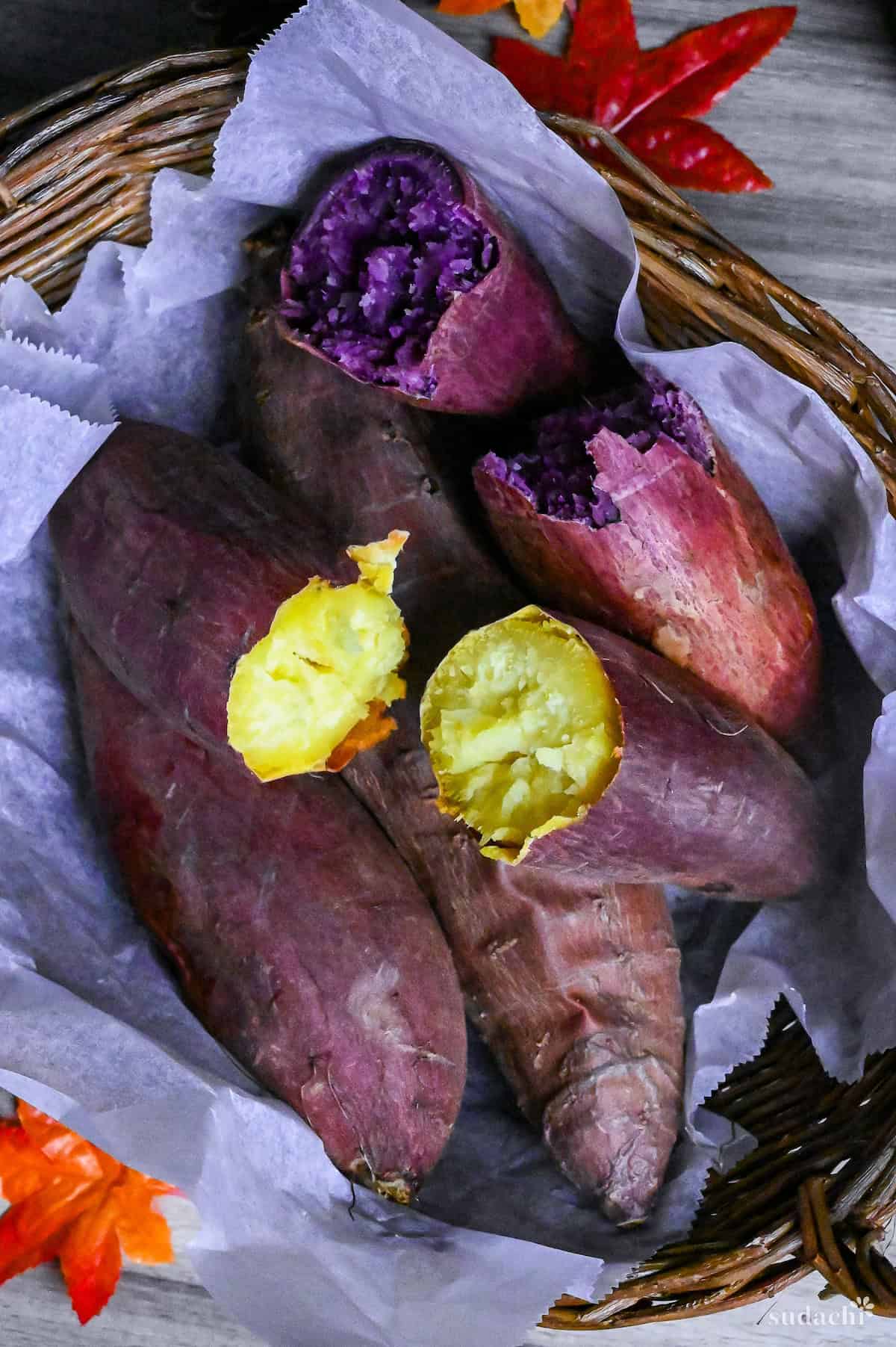 Yaki imo (baked Japanese sweet potatoes) in a woven basket lined with paper and surrounded by pinecones and maple leaves