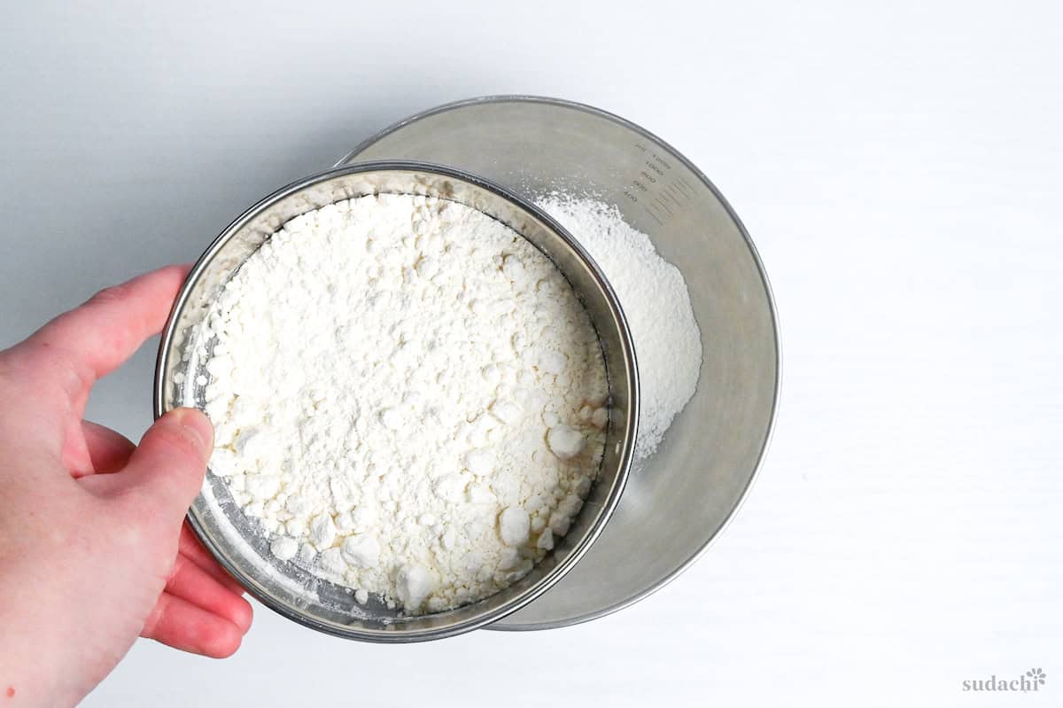 sifting cake flour into a mixing bowl