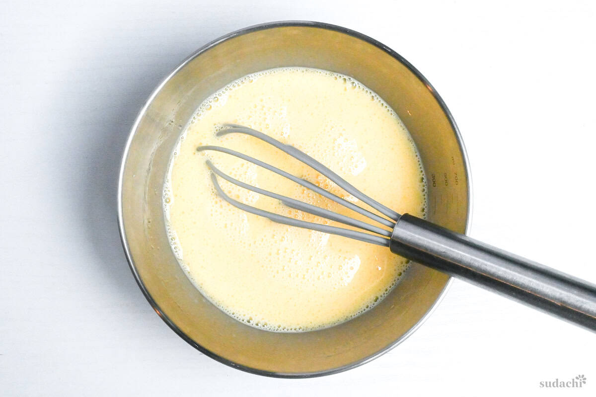 eggs whisked with oil and milk in a bowl