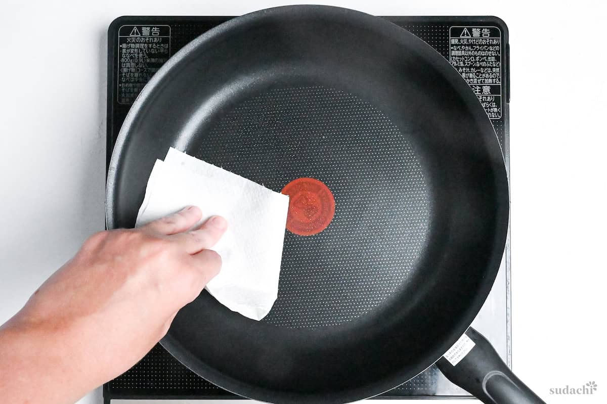 wiping pan with oiled kitchen paper