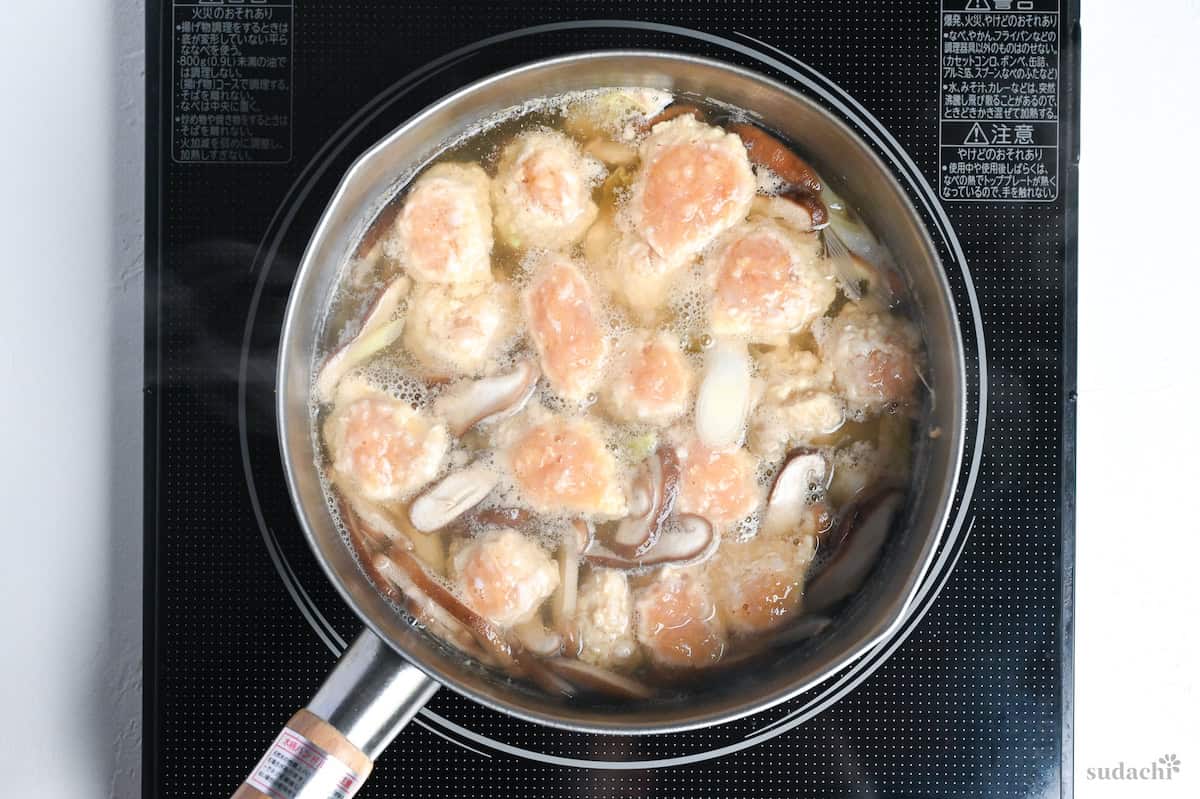 chicken meat balls simmering in dashi with vegetables and glass noodles