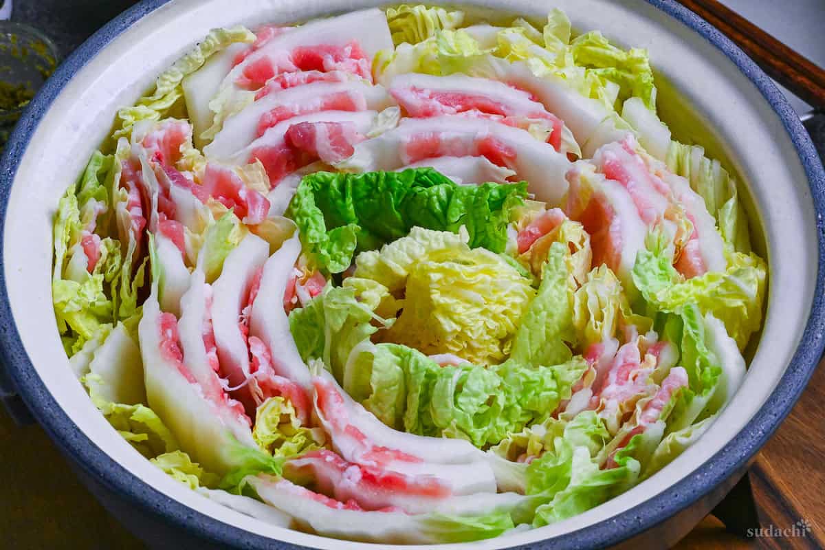 Japanese Mille Feuille Nabe (Pork and Napa Cabbage Hot Pot) in a gray pot on a dark gray background
