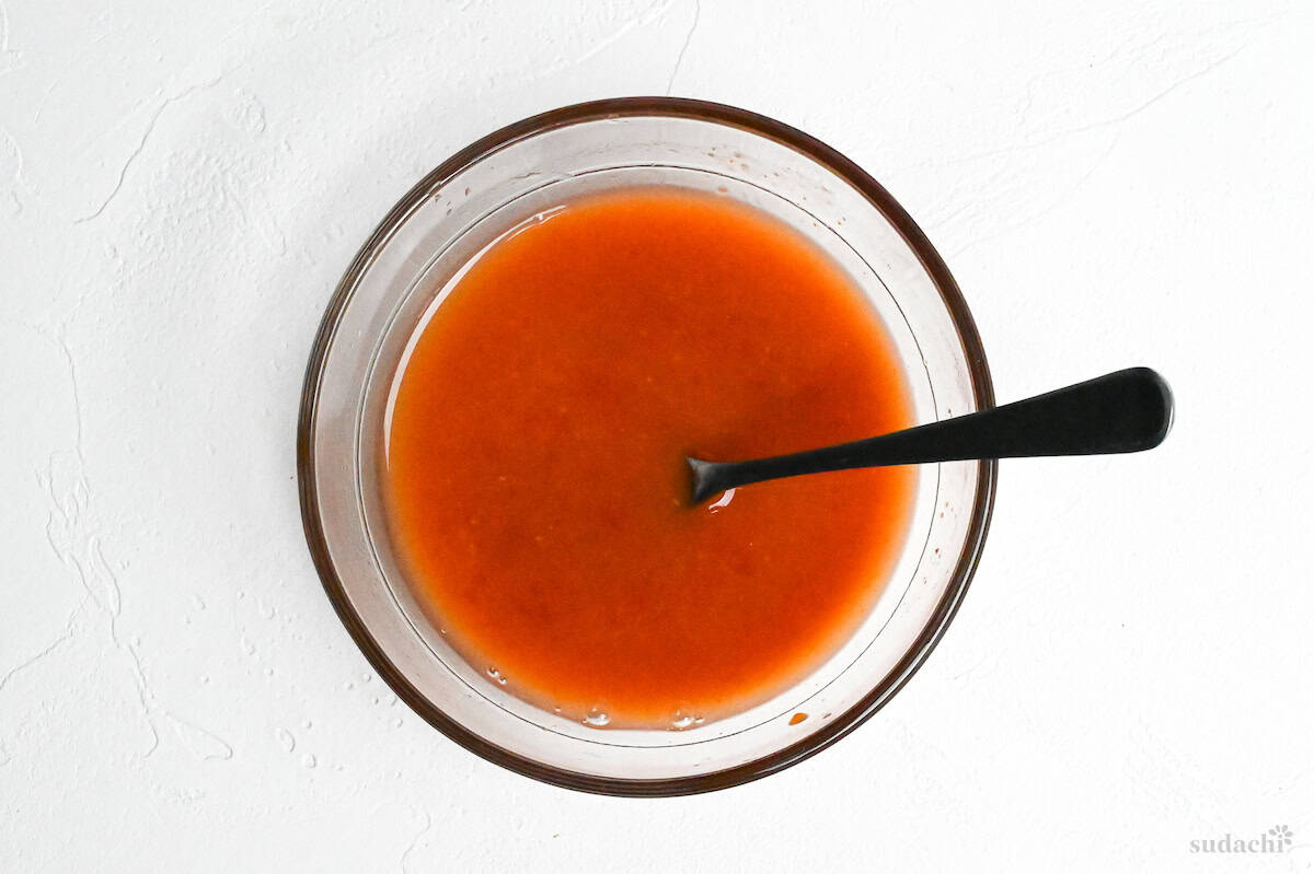 Tori Chili sauce mixed in a small glass bowl on a white background