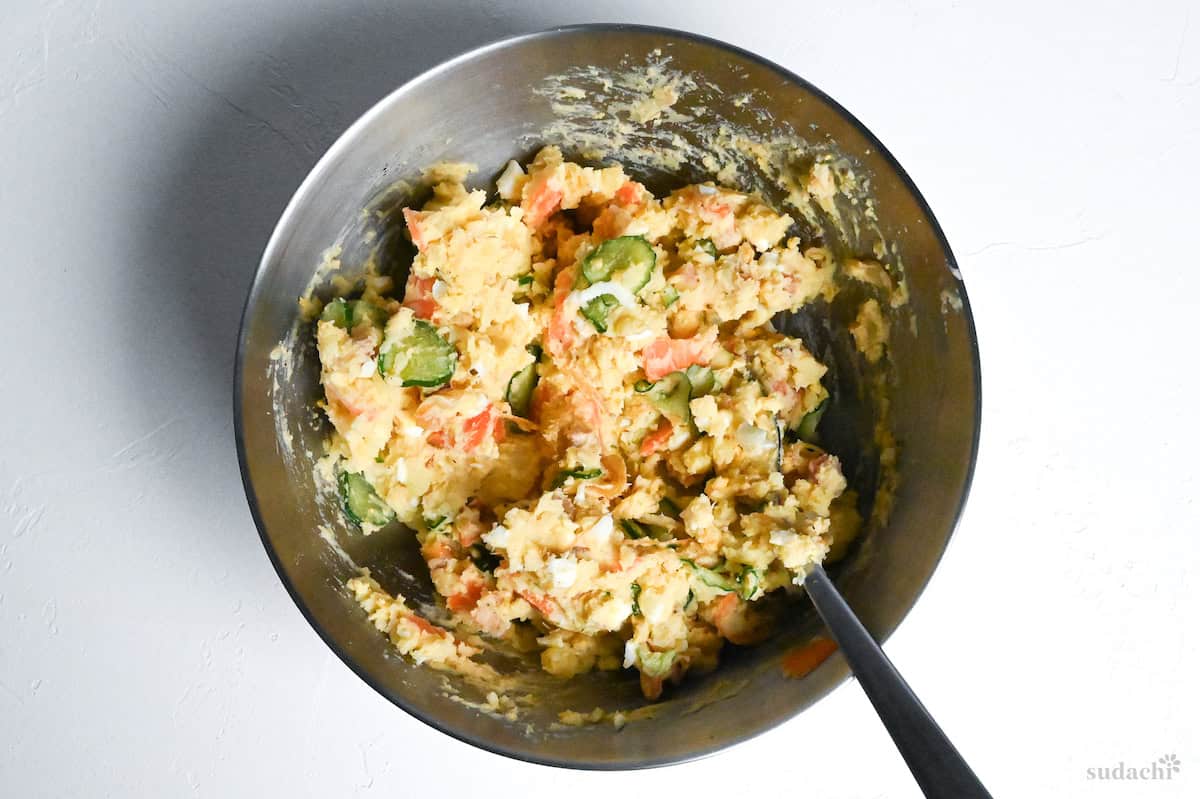 Japanese izakaya style potato salad mixed in a bowll with metal spoon