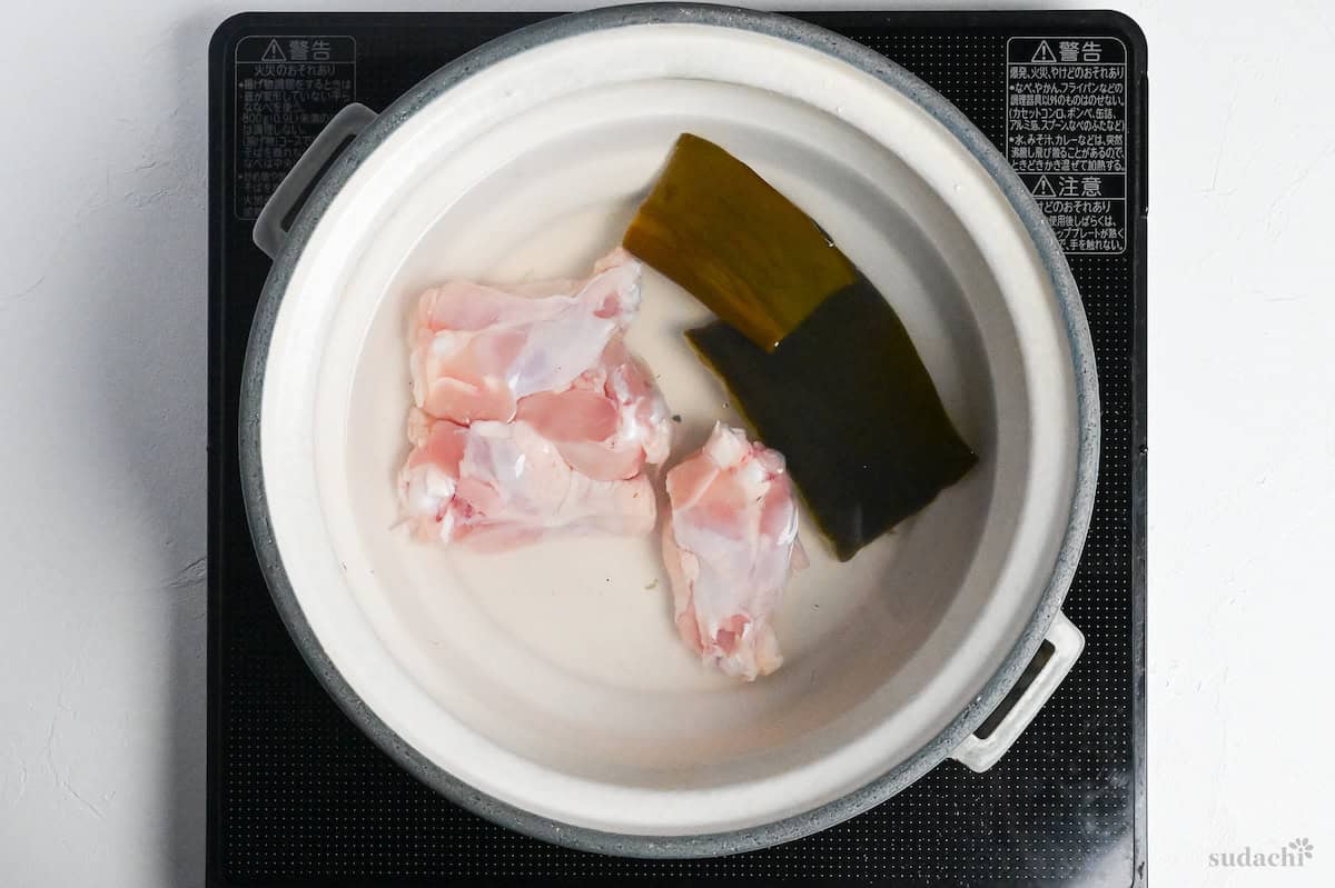 chicken in kombu dashi in a gray ceramic pot on the stove