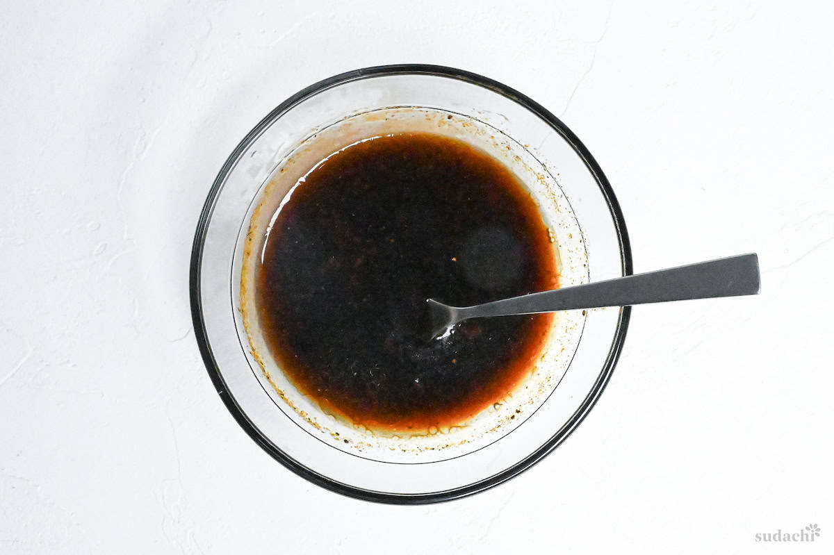 Homemade yakisoba sauce mixed in a clear glass bowl on a white background