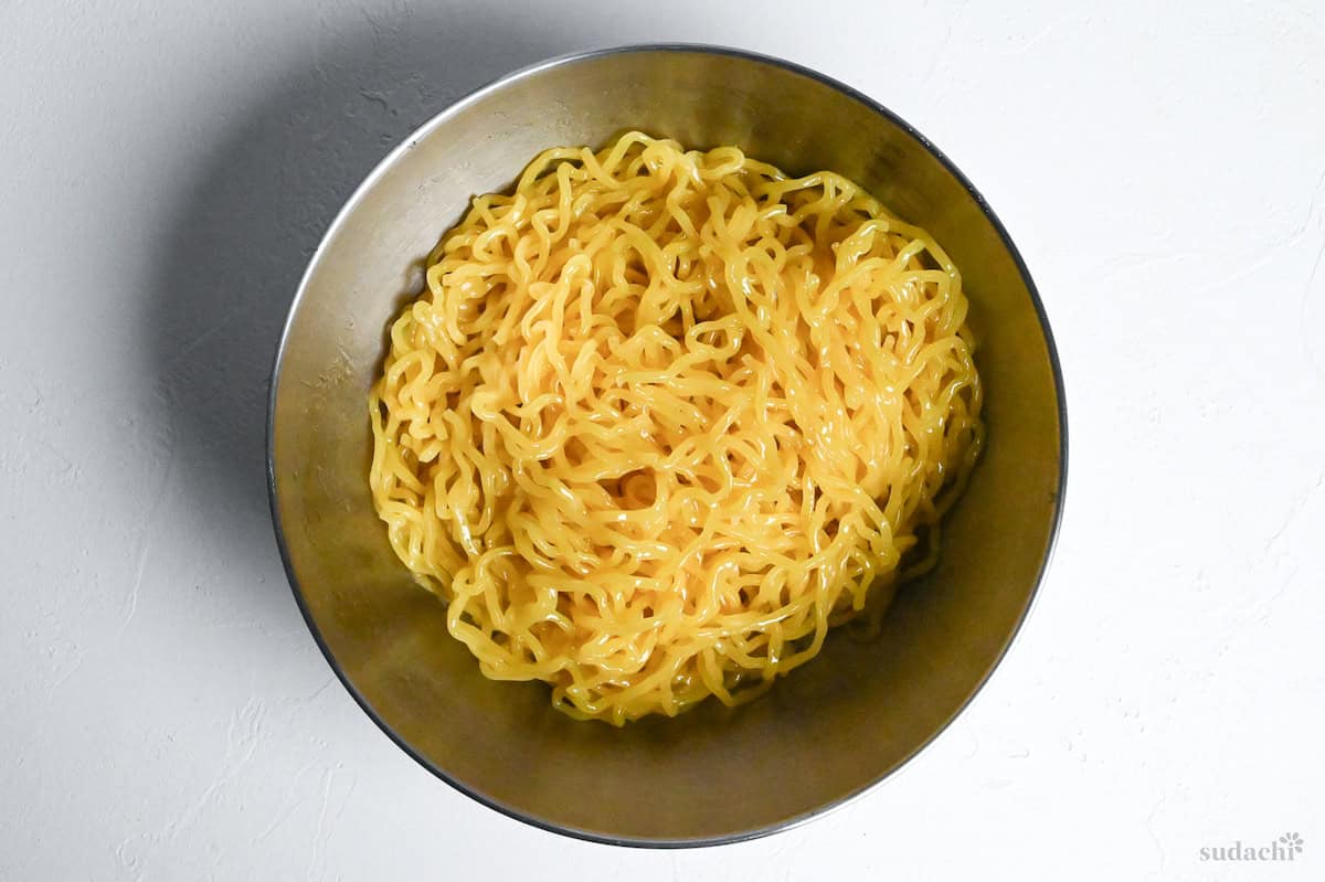 boiled and drained ramen noodles in a bowl coated with sesame oil