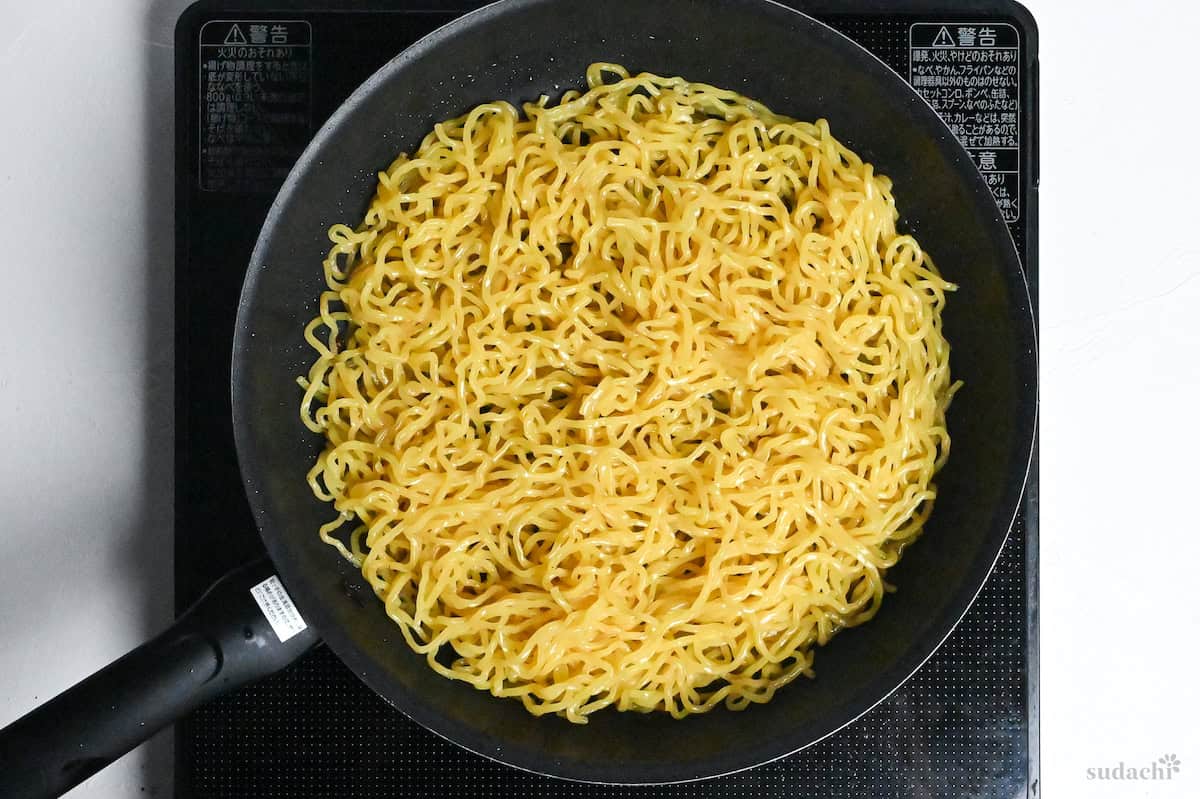 frying yakisoba noodles in a pan on the stove