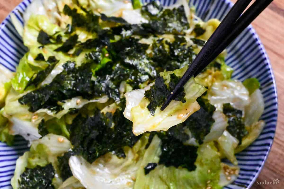yamitsuki lettuce and nori held up with black chopsticks