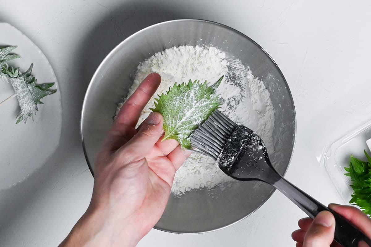 Brushing one side on an ooba (shiso/perilla) leaf with flour to help tempura batter stick