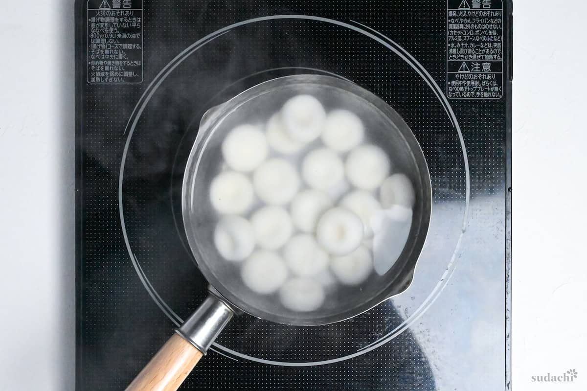 shiratama dango boiling in a pot of water on the stove top