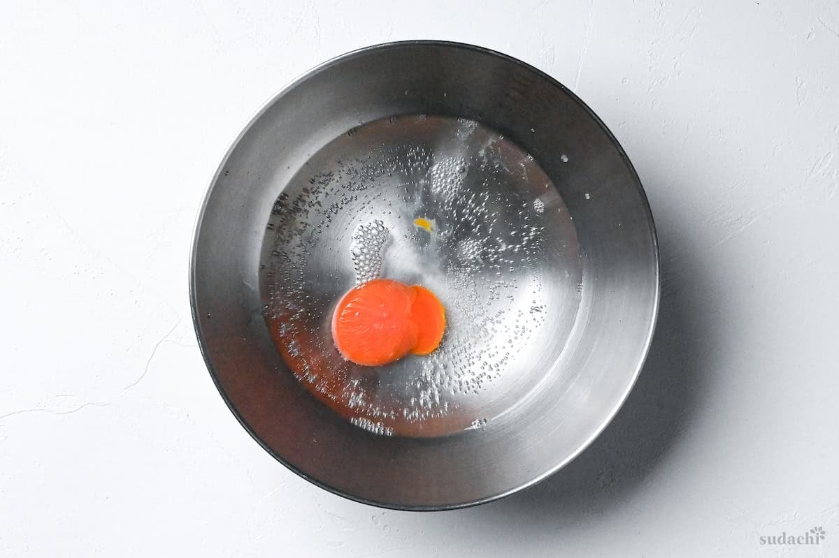 egg yolk and chilled water in a steel mixing bowl