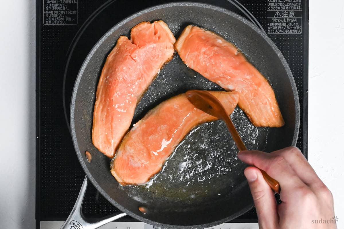 basting half-cooked salmon fillets with hot butter